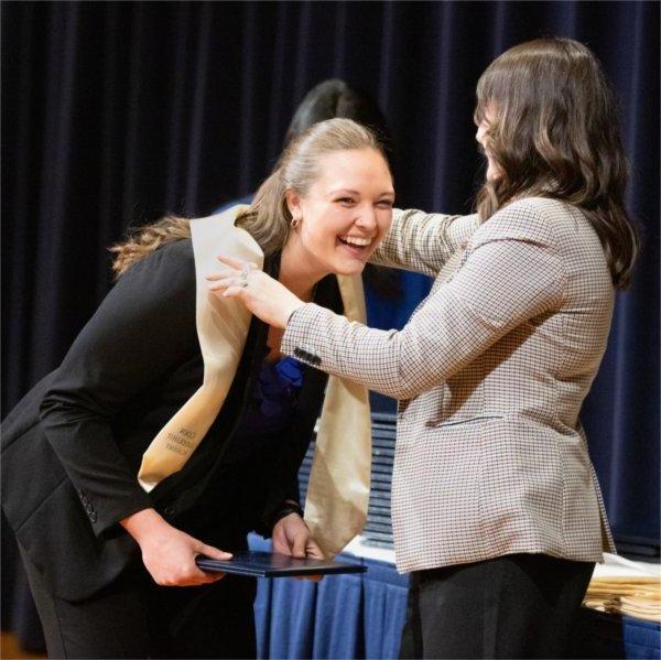 A fellow of the 2024 cohort for the Peter C. Cook Leadership Academy receives her certificate and stole.